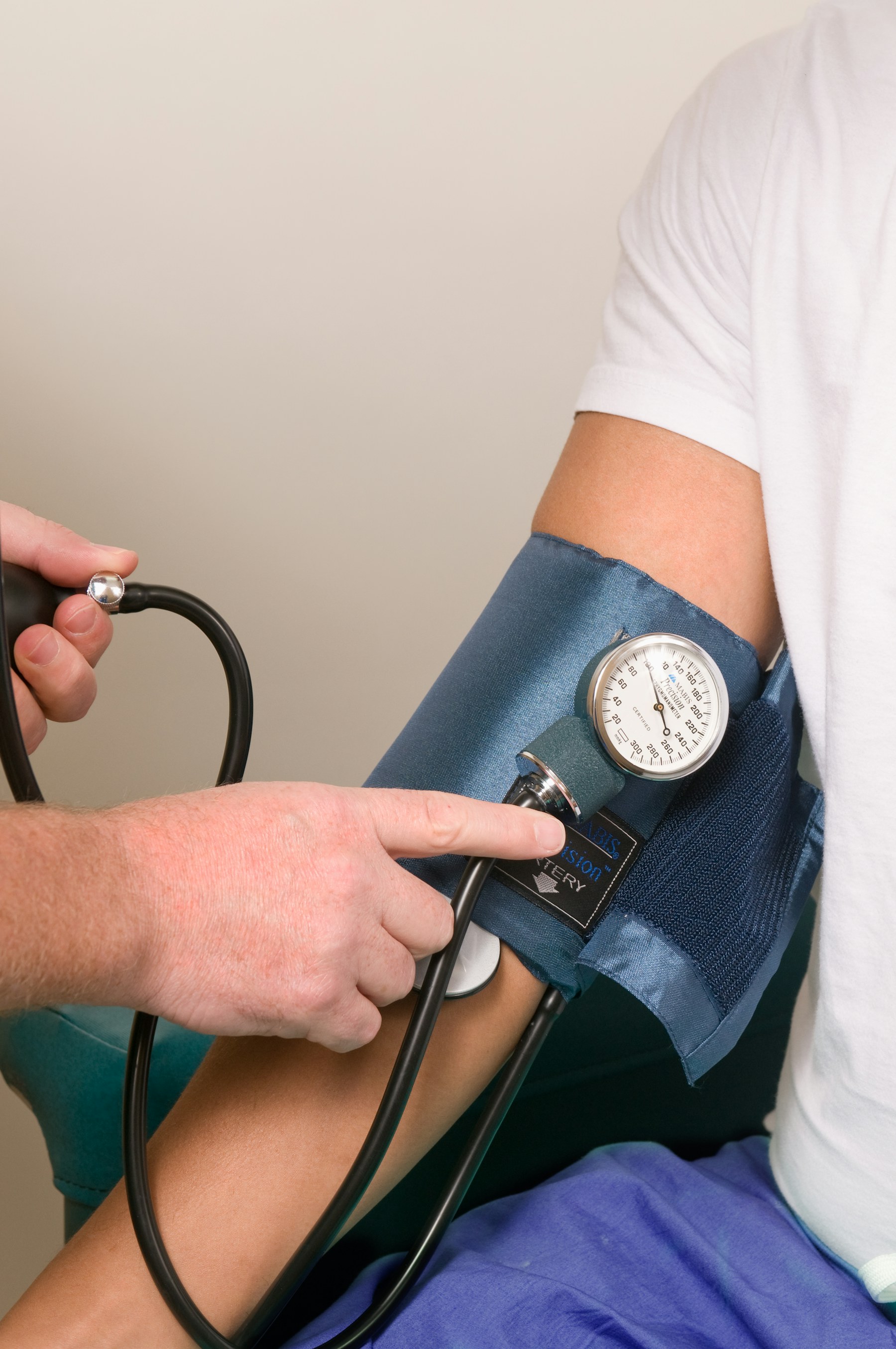 Clinician checking a patient's blood pressure during an exam