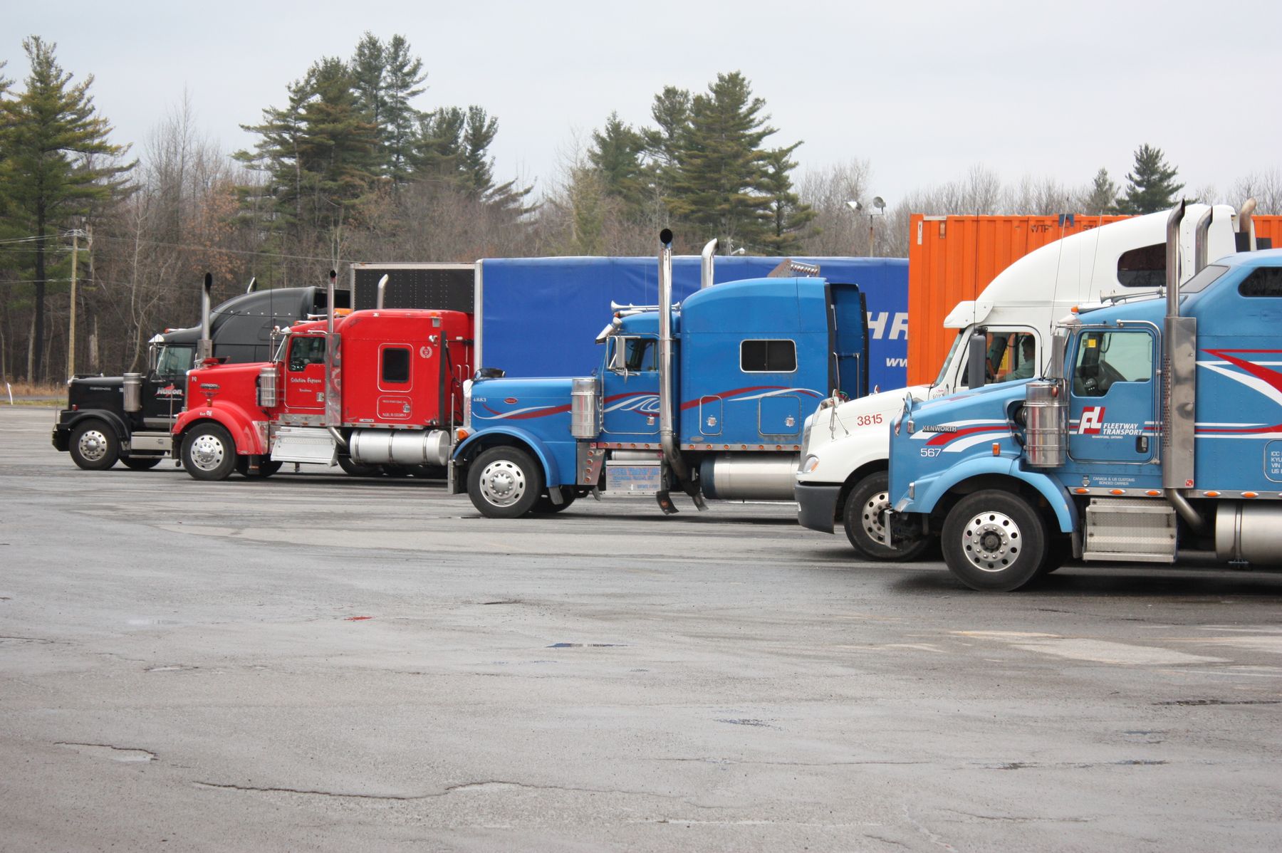 Commercial trucks parked together at a fleet yard